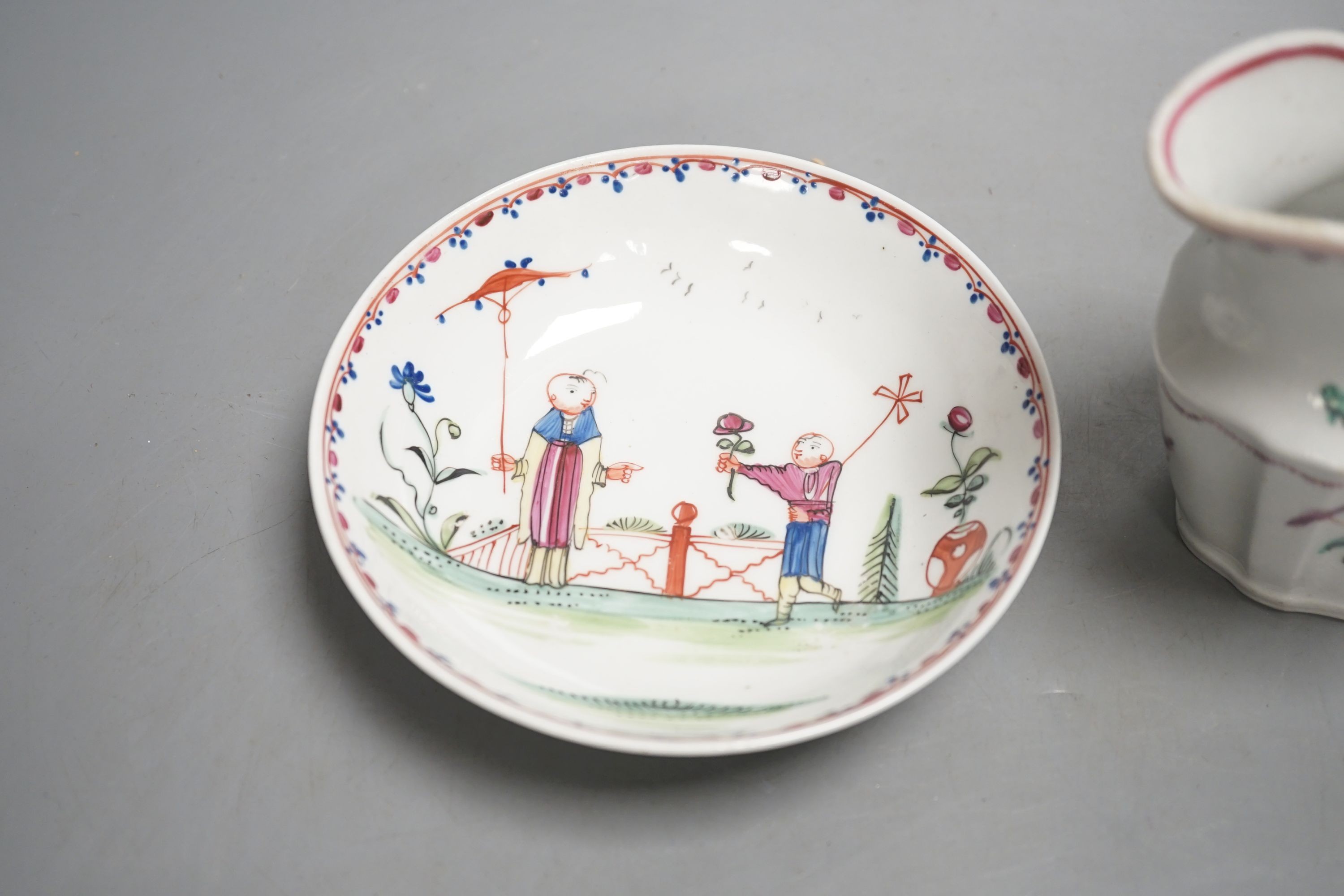 A New Hall teabowl and saucer painted with oriental children with either a pinwheel or a parasol pattern no. 20 and a cream jug painted with flowers pattern 253 C.1785